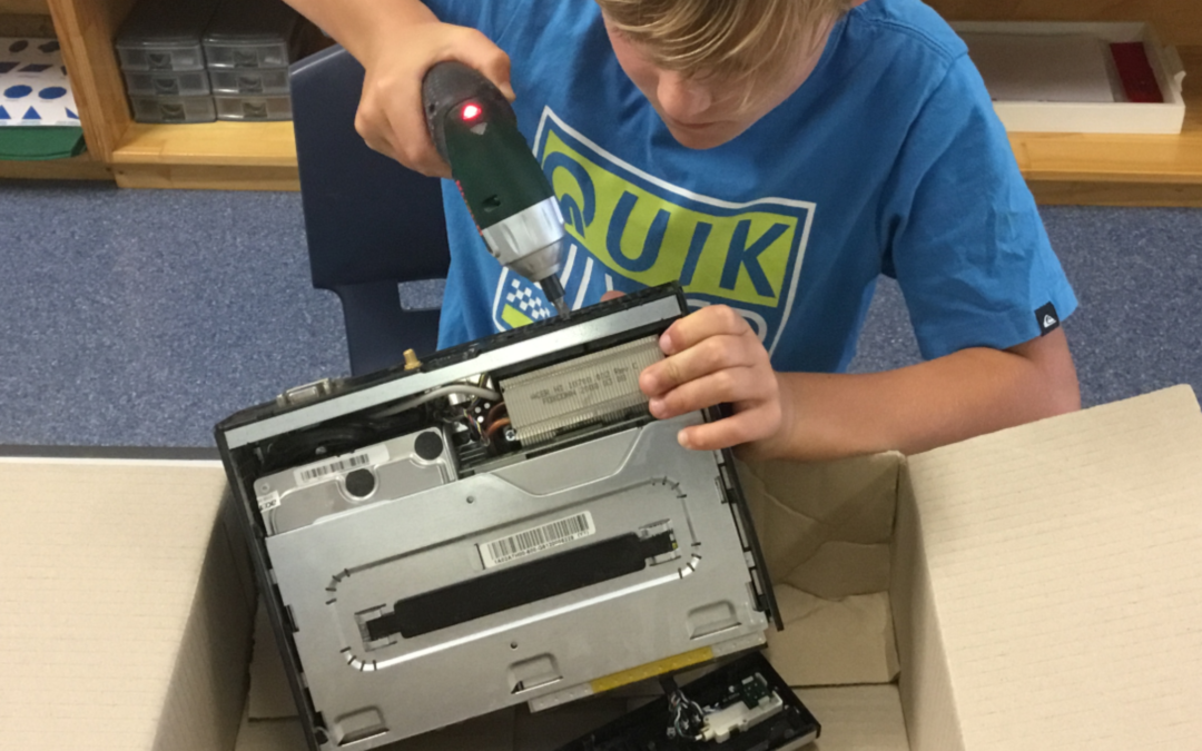 Rockingham Montessori School boy using a drill to fix a computer
