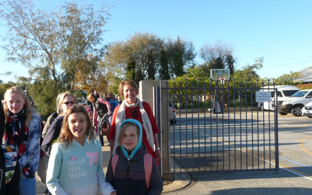 Rockingham Montessori male and female students dressed in sweaters while walking outside school with their teacher