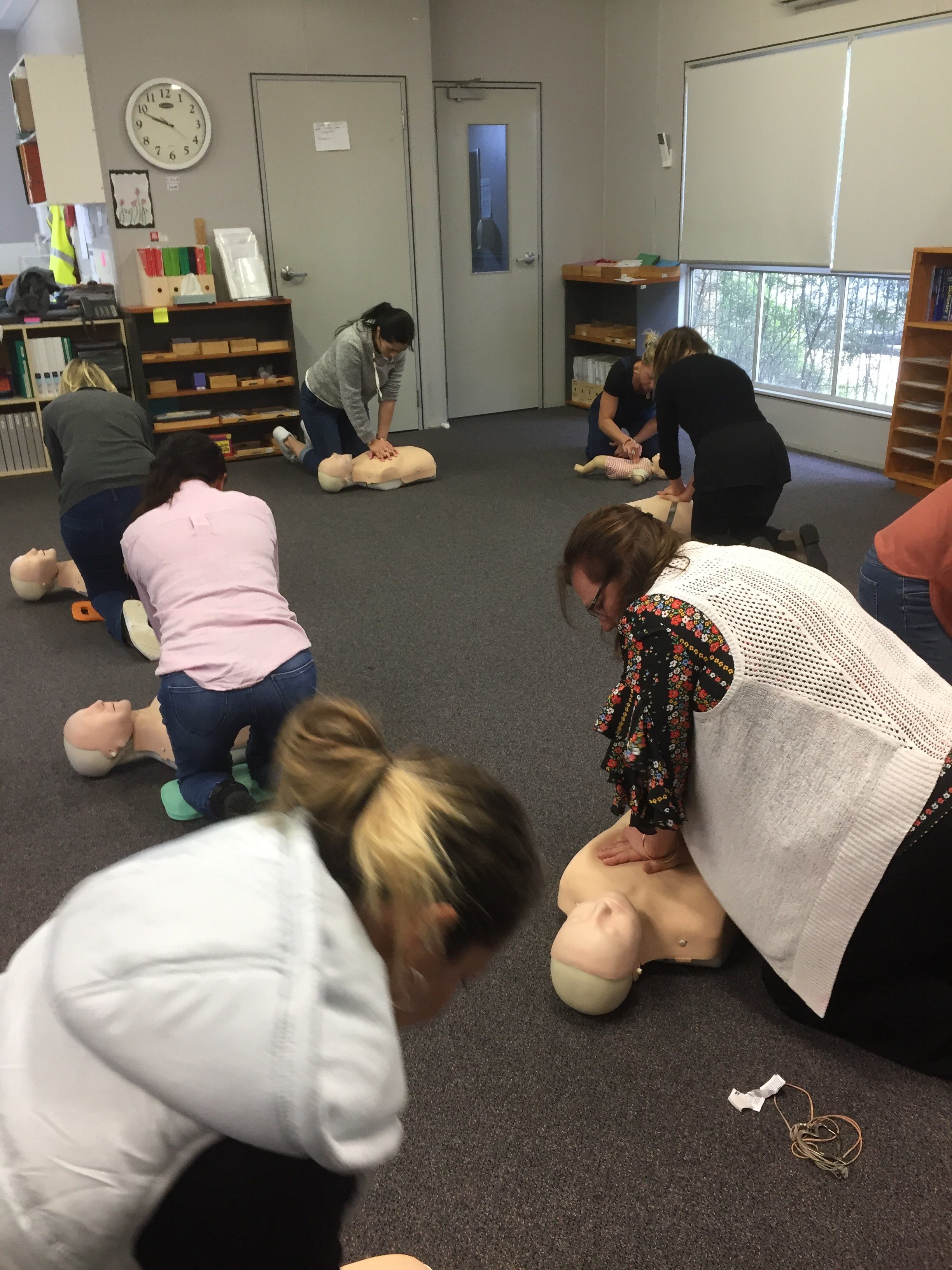 Rockingham Montessori faculty practicing CPR or Life Saving Skills with a Dummy