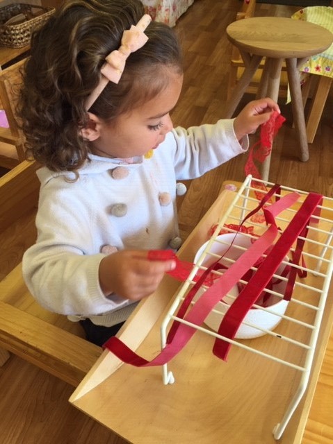 Rockingham Montessori infant toddler tying ribbons