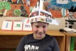 Rockingham Montessori student wearing a paper hat during Upper Primary's art showcase