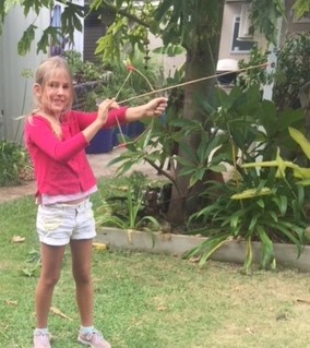 Rockingham Montessori School female student shooting a bow and arrow