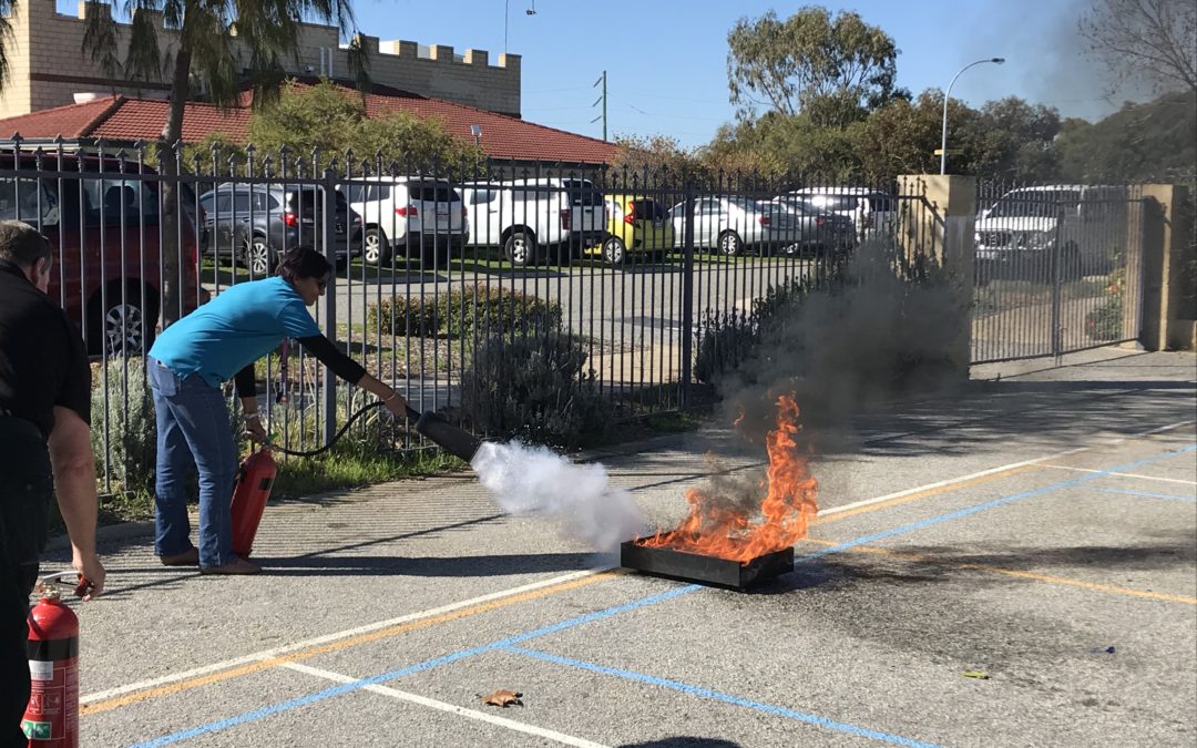 RMS teachers undergoing safety training putting out fire