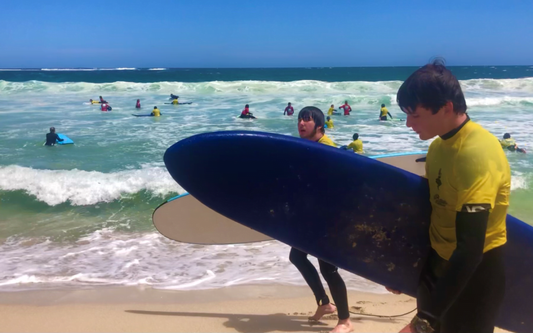 RMS students surfing by the beach for Upper Primary Camp program