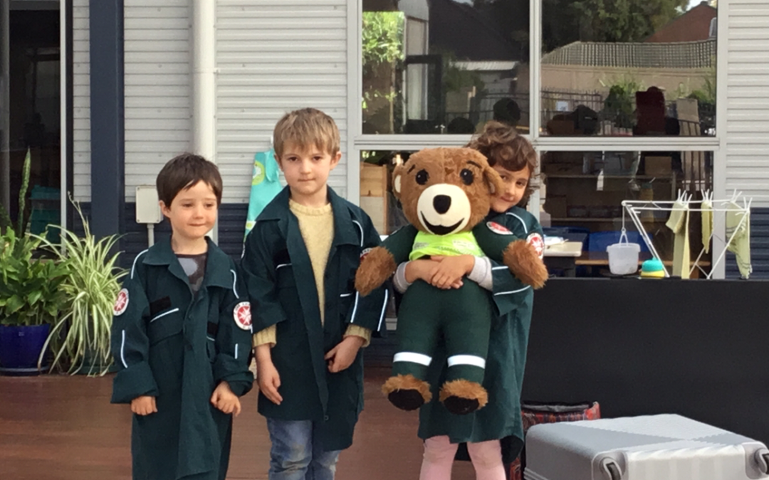 Rockingham Montessori School male and female students wearing a coat and hugging a teddy bear